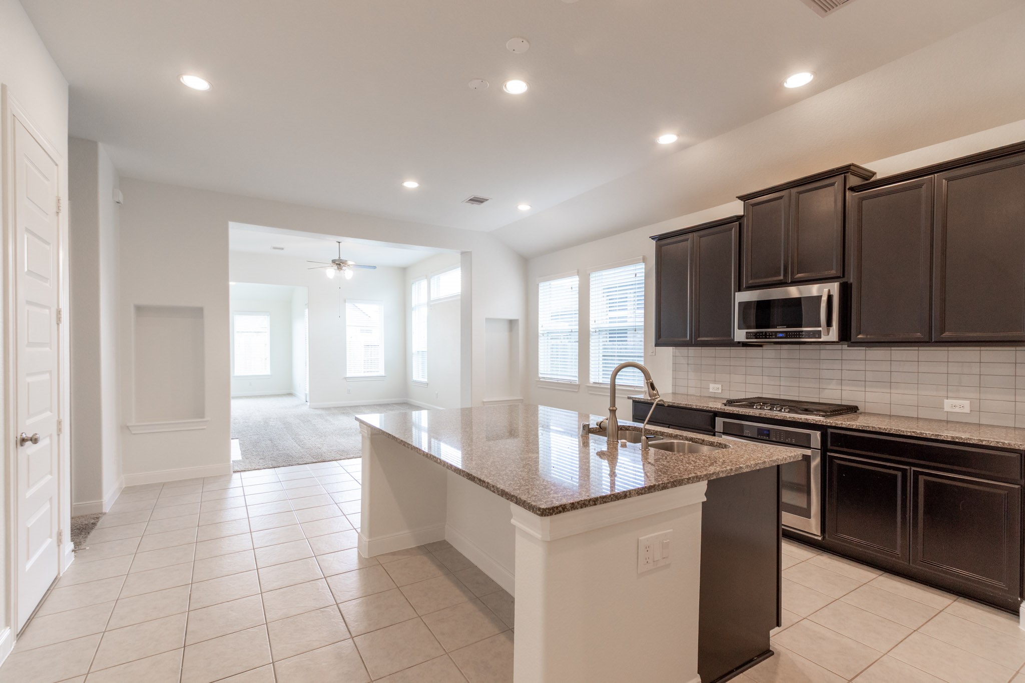 2312 Jessamine Heights Lane Pearland, TX 77089 - Photo 3 of 49 a kitchen with stainless steel appliances granite countertop a sink and a stove top oven with wooden floor