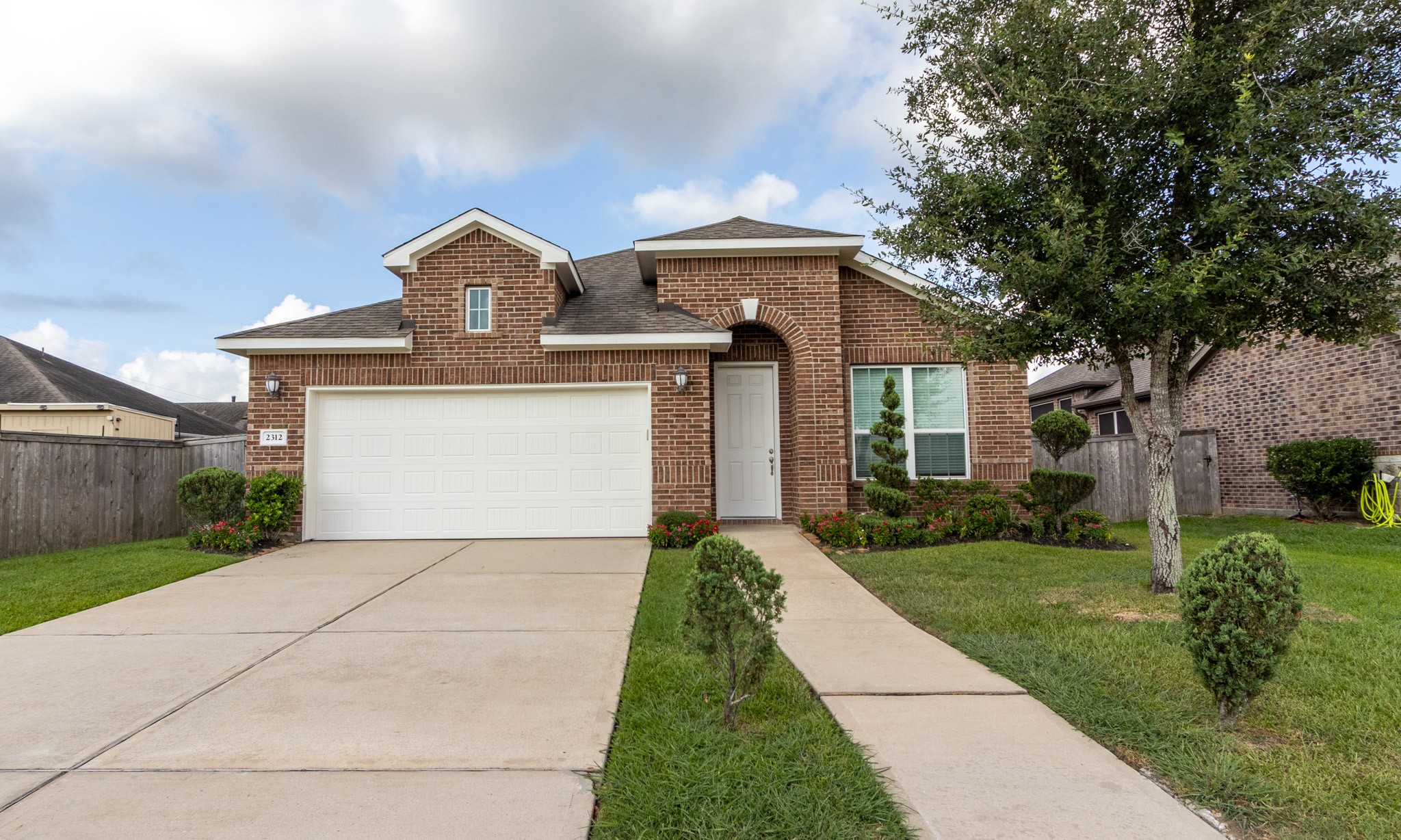 2312 Jessamine Heights Lane Pearland, TX 77089 - Photo 38 of 49 a front view of a house with a garden and yard