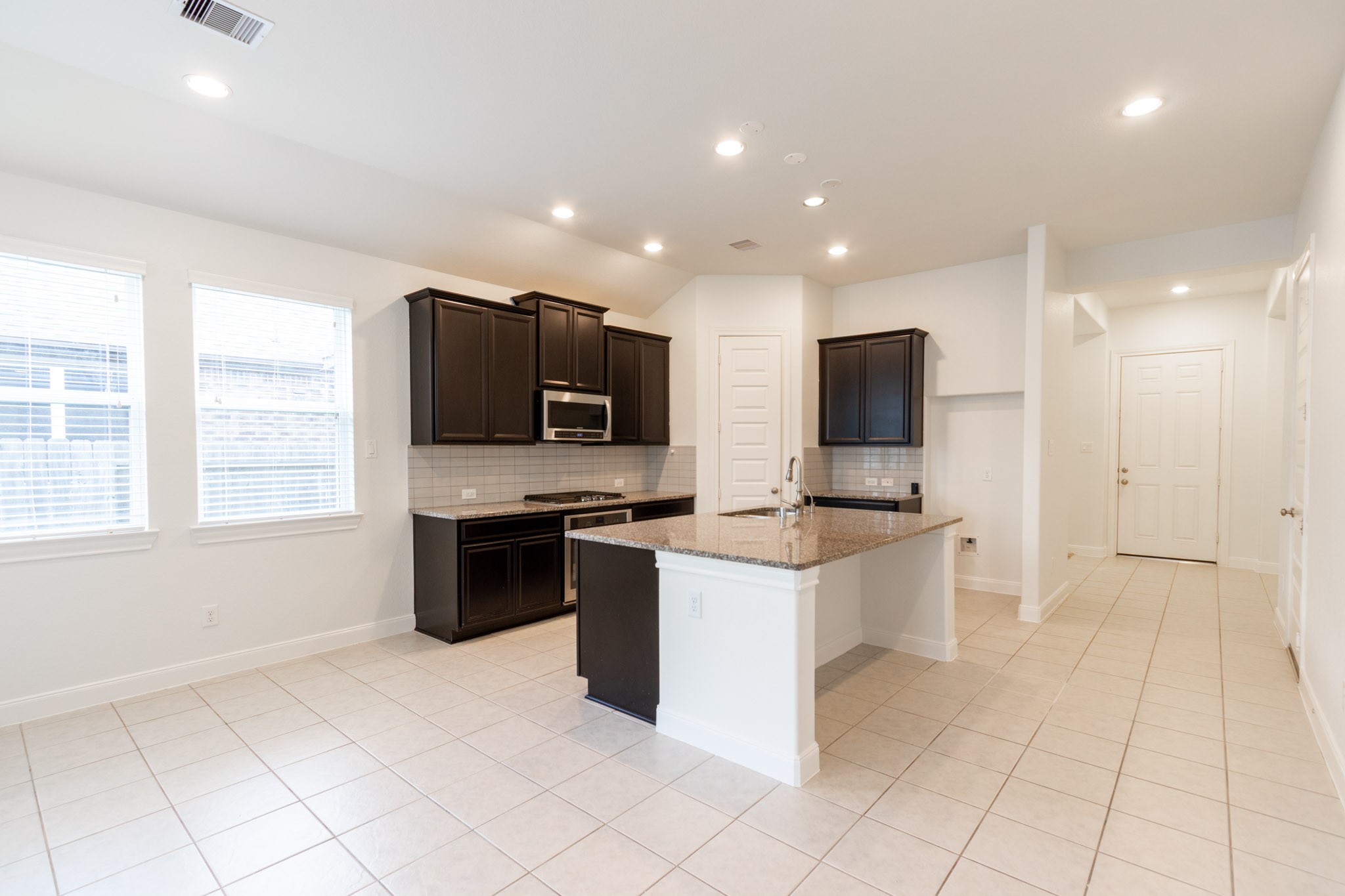 2312 Jessamine Heights Lane Pearland, TX 77089 - Photo 7 of 49 a large kitchen with stainless steel appliances kitchen island granite countertop a sink and a stove top oven