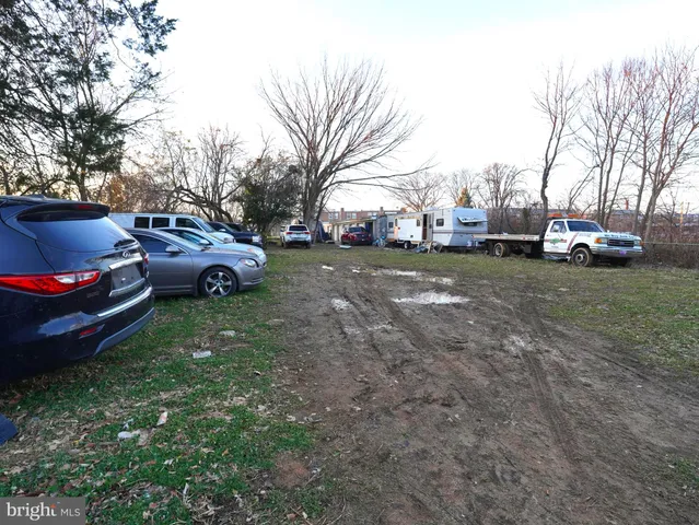 a view of a backyard with a car parked in the forest