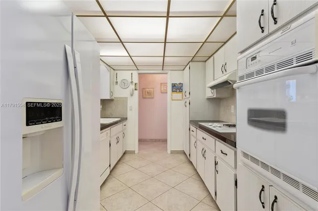 a kitchen with granite countertop a white stove top oven and sink
