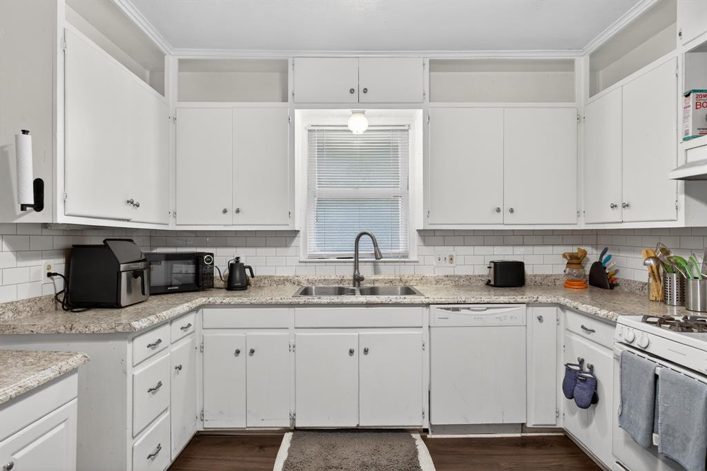 1111 North Austin Street Denton, TX 76201 - Photo 8 of 28 a kitchen with granite countertop white cabinets and white appliances