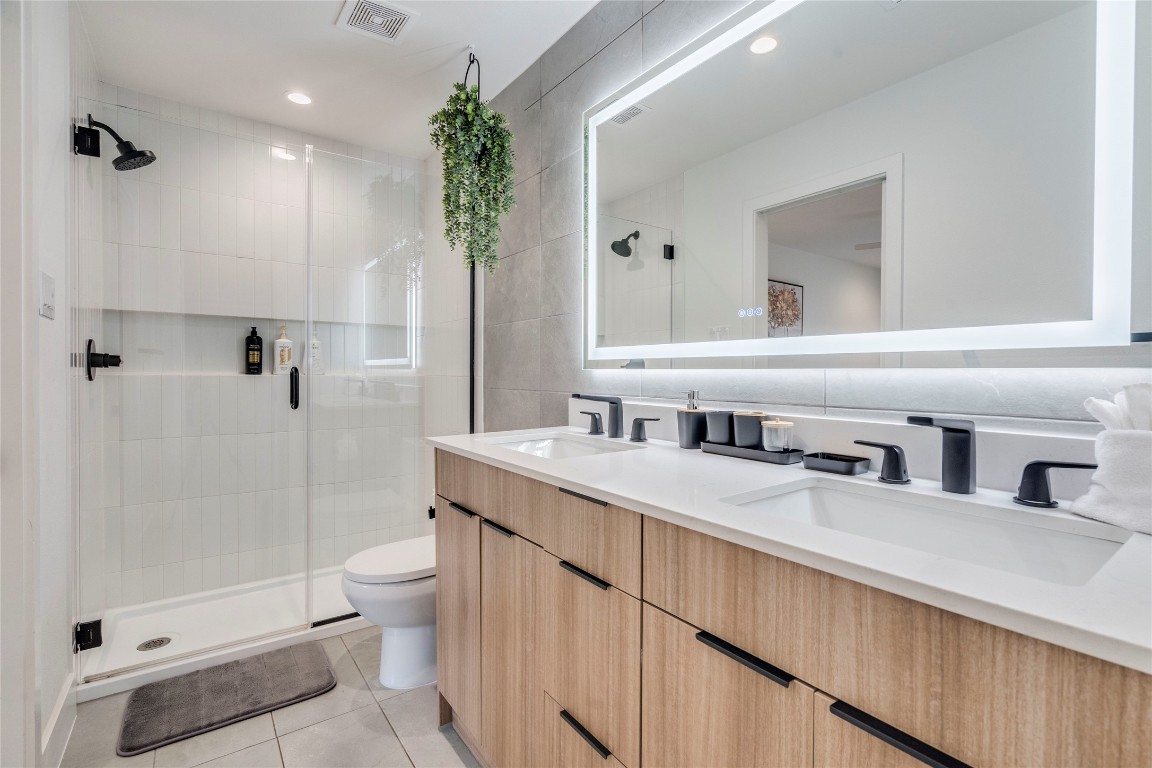 1902 Albury Cove, Unit C Austin, TX 78758 - Photo 15 of 25 a bathroom with a double vanity sink toilet and shower