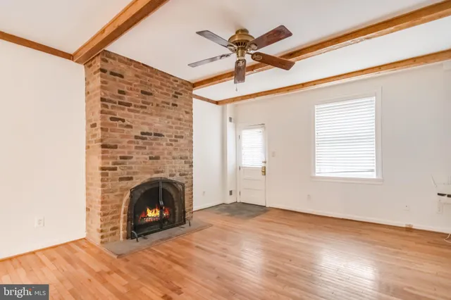 a view of empty room with fireplace and wooden floor