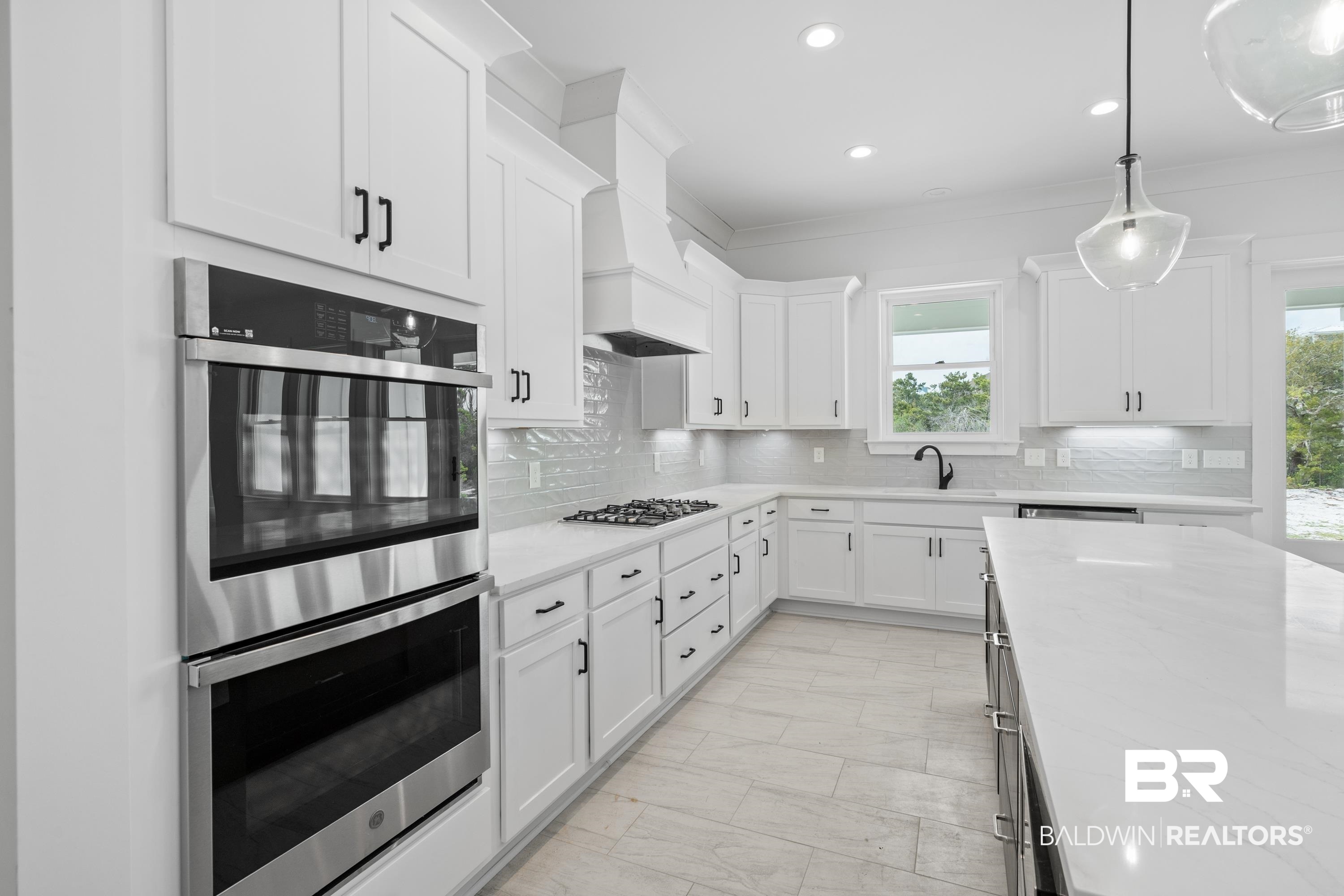 30650 Ono N Loop West Orange Beach, AL 36561 - Photo 11 of 38 Kitchen with stainless steel appliances, plenty of natural light, light marble finish flooring, white cabinets, and recessed lighting