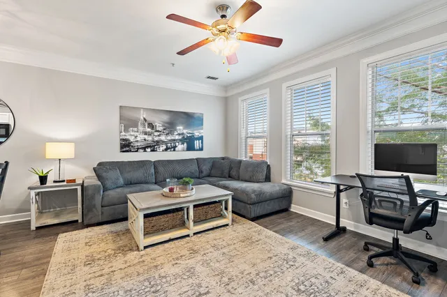 a living room with furniture a flat screen tv and a window