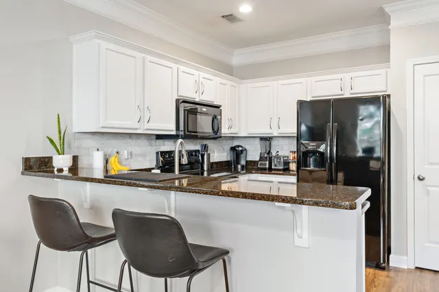 a kitchen with stainless steel appliances granite countertop a stove refrigerator sink and cabinets