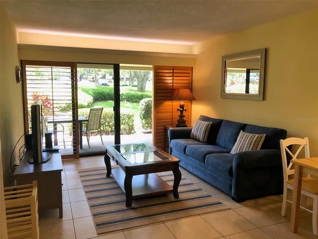 a living room with furniture and a floor to ceiling window