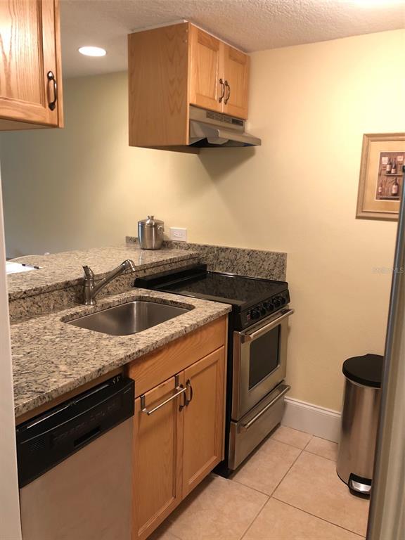 36750 US Highway 19 North, Unit 23107 Palm Harbor, FL 34683 - Photo 5 of 16 a kitchen with stainless steel appliances granite countertop a sink stove and cabinets