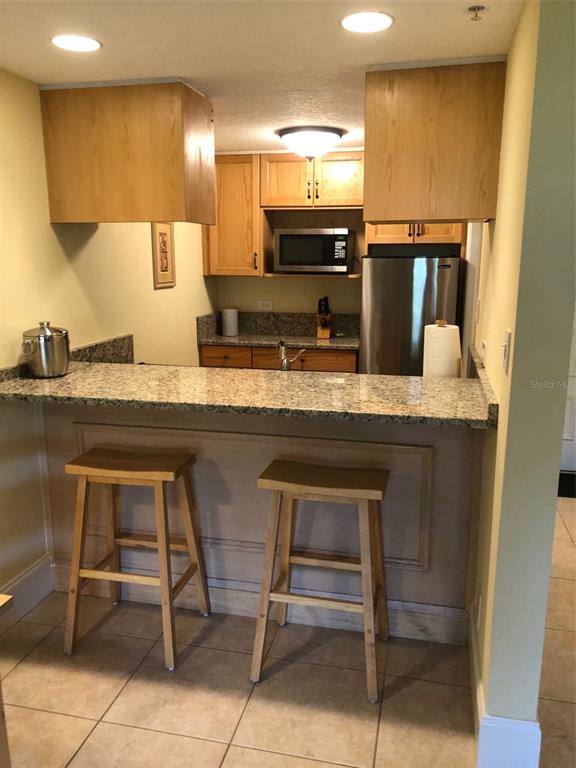 36750 US Highway 19 North, Unit 23107 Palm Harbor, FL 34683 - Photo 7 of 16 a kitchen with stainless steel appliances granite countertop a sink and a refrigerator