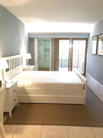 a large bed sitting in a bedroom next to a large window