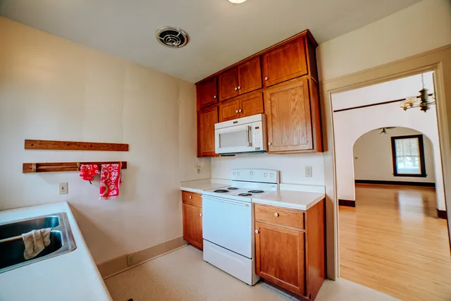a utility room with cabinets a sink and a window