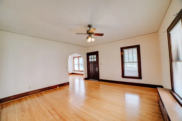 a view of an empty room with window and wooden floor
