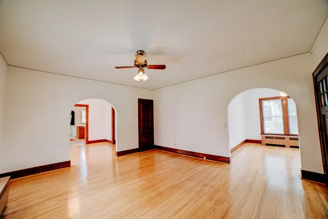 a view of an empty room with wooden floor