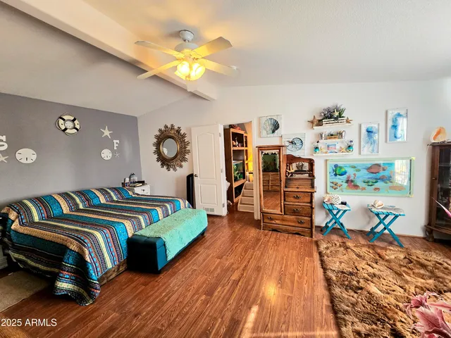 a bedroom with a bed and a wooden floor