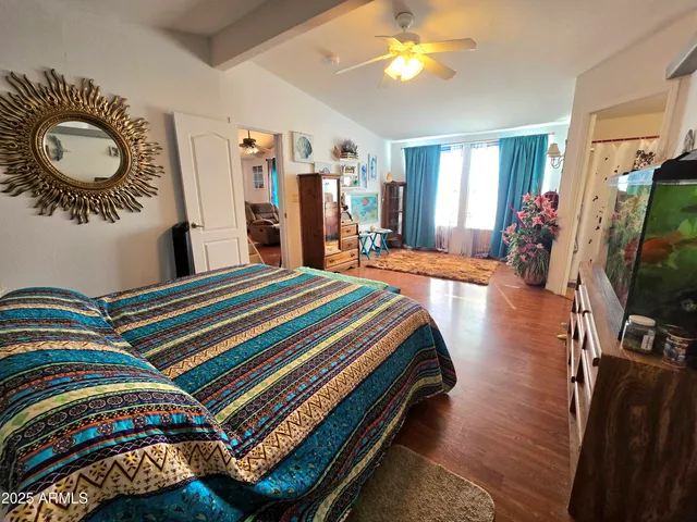 a bedroom with bed and a flat tv screen on dresser