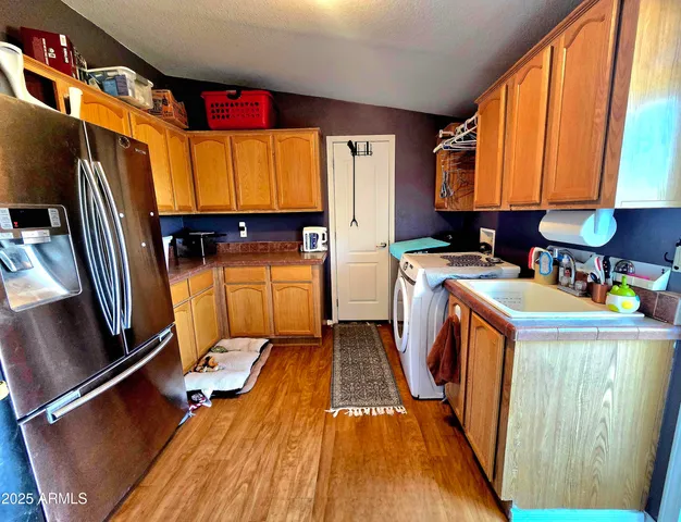 a storage room with stainless steel appliances wooden floor and a window