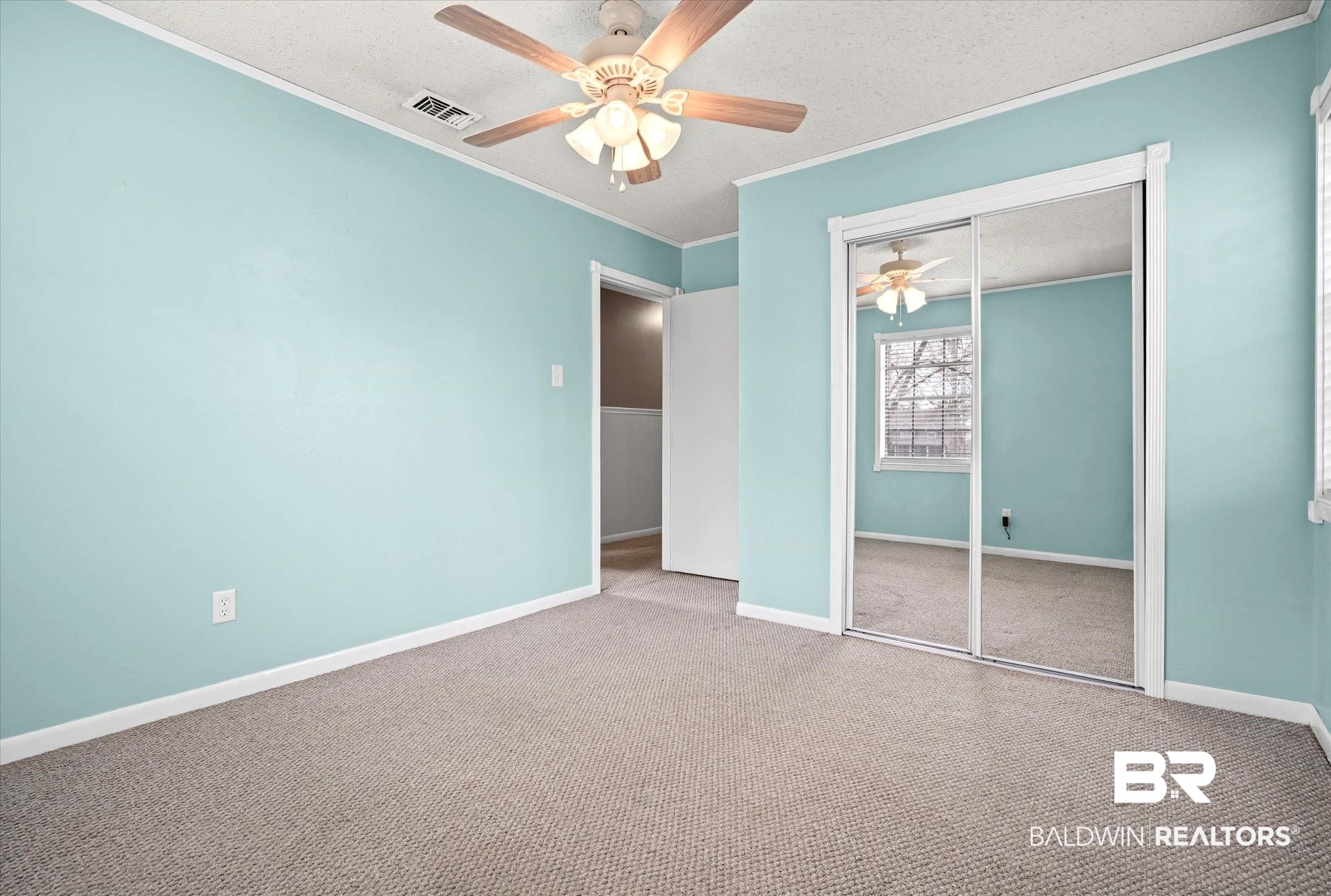 8090 Murray Hill Road Irvington, AL 36544 - Photo 24 of 40 Unfurnished bedroom with a textured ceiling, a ceiling fan, carpet, a closet, and ornamental molding