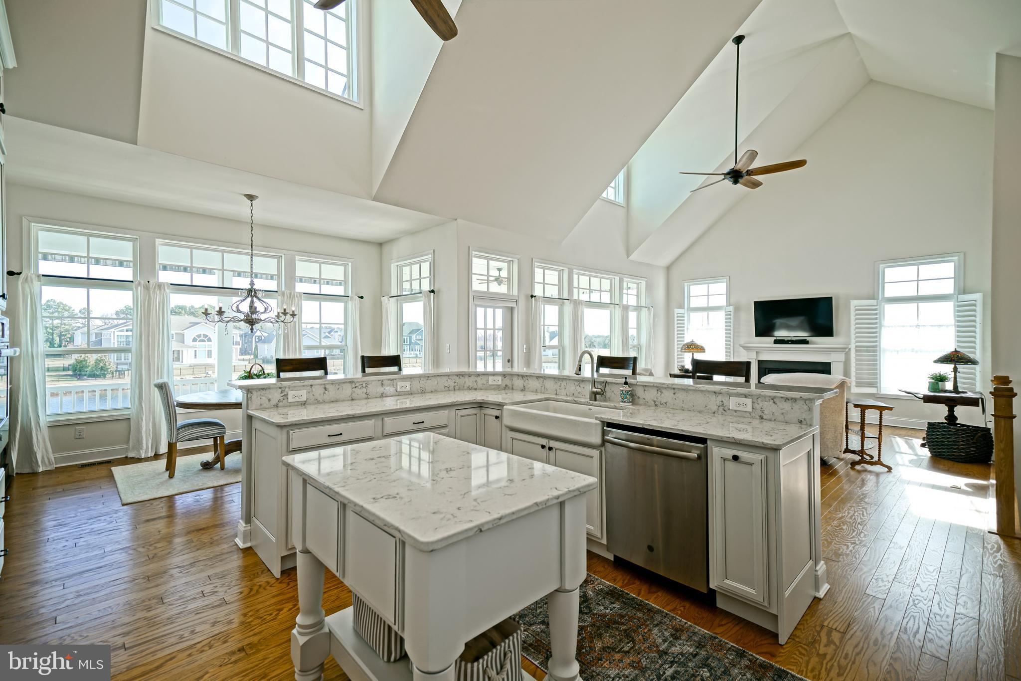 36903 Crossrail Way Lewes, DE 19958 - Photo 28 of 120 a kitchen with a stove a sink dishwasher a refrigerator and dining table with wooden floor