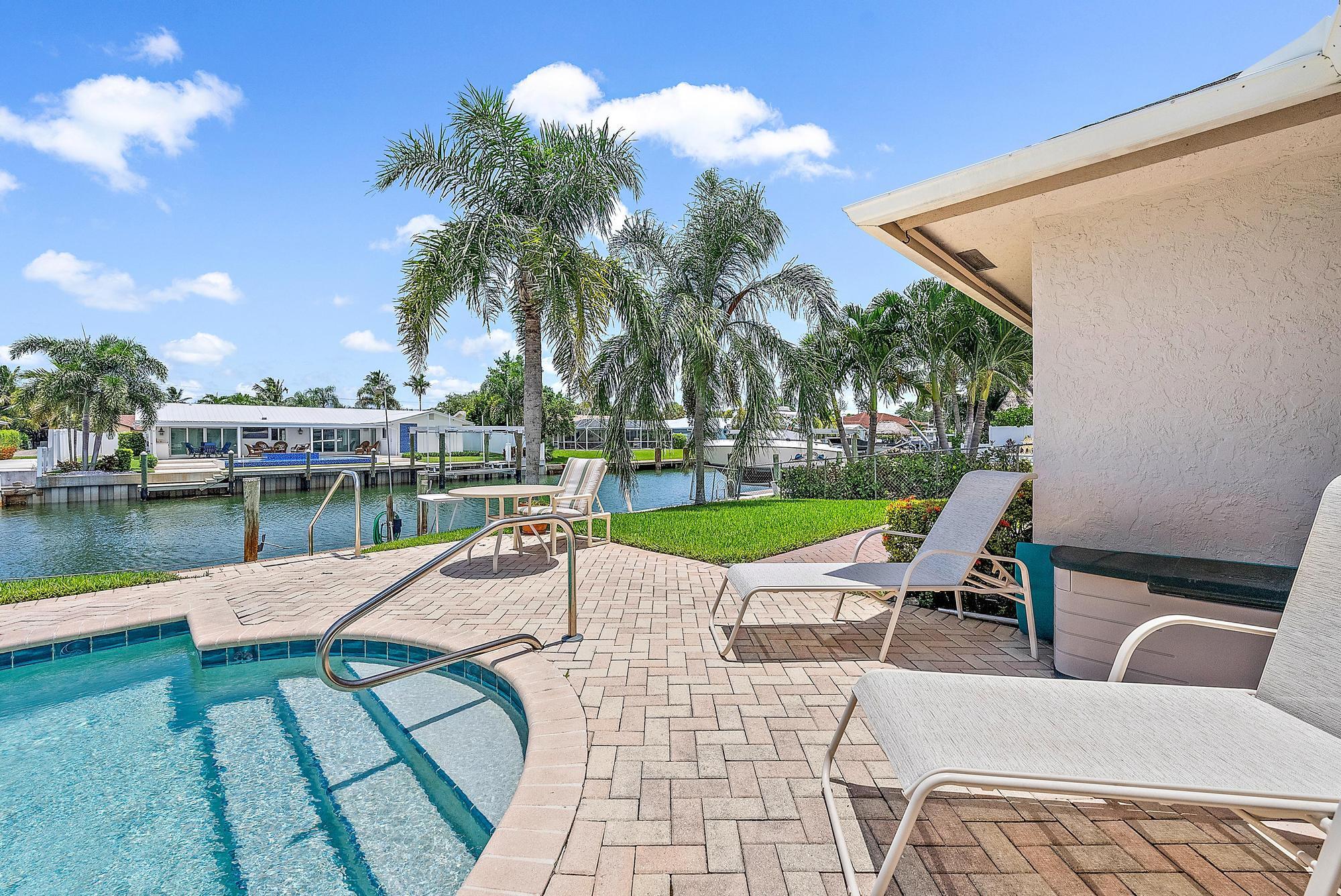 925 Dolphin Drive Jupiter, FL 33458 - Photo 28 of 37 a view of a swimming pool with a lounge chairs