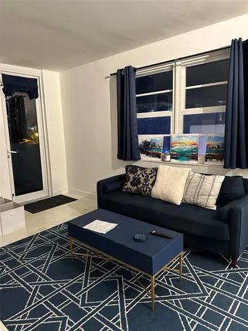 a living room with a couch and a stove with wooden floor