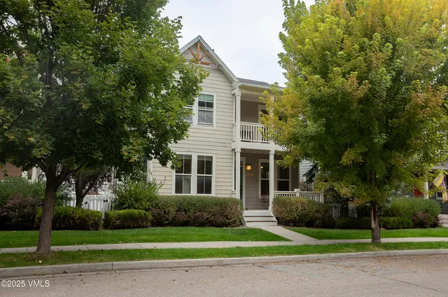 a view of a house with a yard and large trees