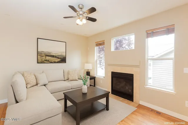 a living room with furniture a fireplace and a window