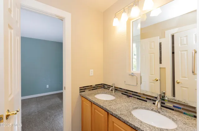 a bathroom with a granite countertop sink and a mirror