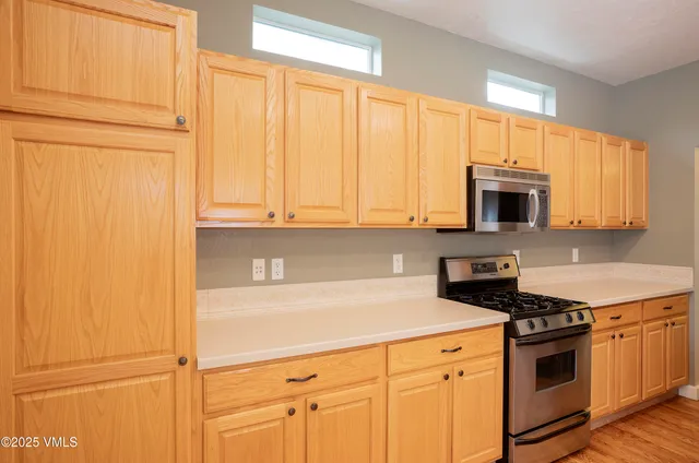 a kitchen with stainless steel appliances a stove a microwave and cabinets