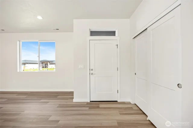 a view of kitchen with kitchen island wooden floor center island and stainless steel appliances