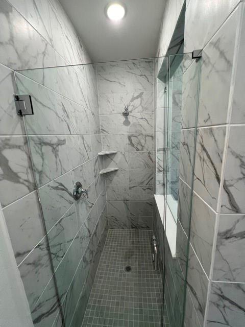 1407 Cartona Road Fate, TX 75087 - Photo 21 of 21 Walk-in shower featuring large format marbled tile walls and a mosaic tile floor