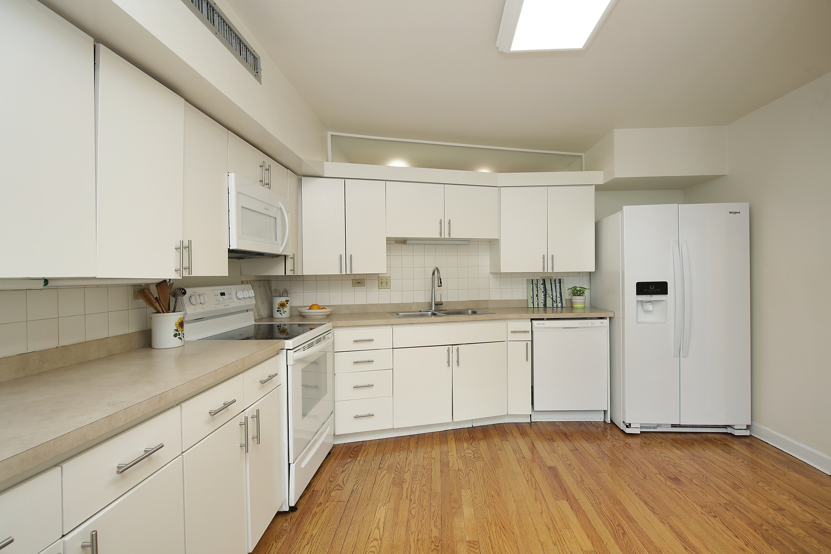 2653 Sheridan Road Evanston, IL 60201 - Photo 5 of 17 a kitchen with granite countertop white cabinets stainless steel appliances a sink and wooden floor