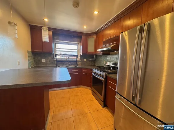 a kitchen with stainless steel appliances granite countertop a refrigerator a sink and a stove