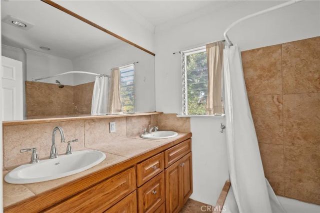 a bathroom with a granite countertop sink and a large mirror