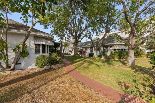 a view of a white house with a large tree