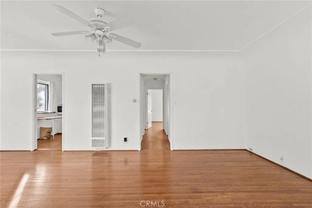 a view of a room with wooden floor and ceiling fan
