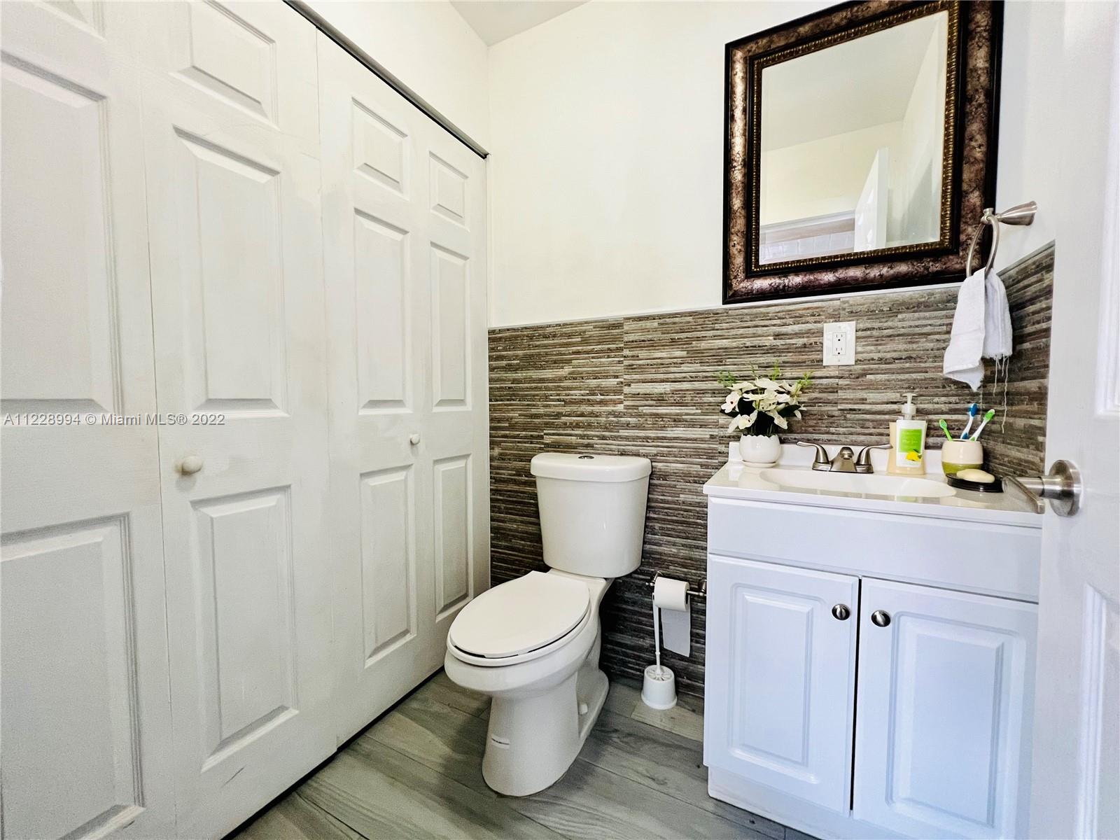 599 West 46th Place Hialeah, FL 33012 - Photo 14 of 25 a bathroom with a toilet sink and mirror