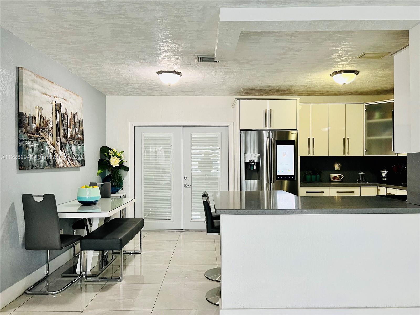 599 West 46th Place Hialeah, FL 33012 - Photo 6 of 25 a living room with furniture a flat screen tv and kitchen view