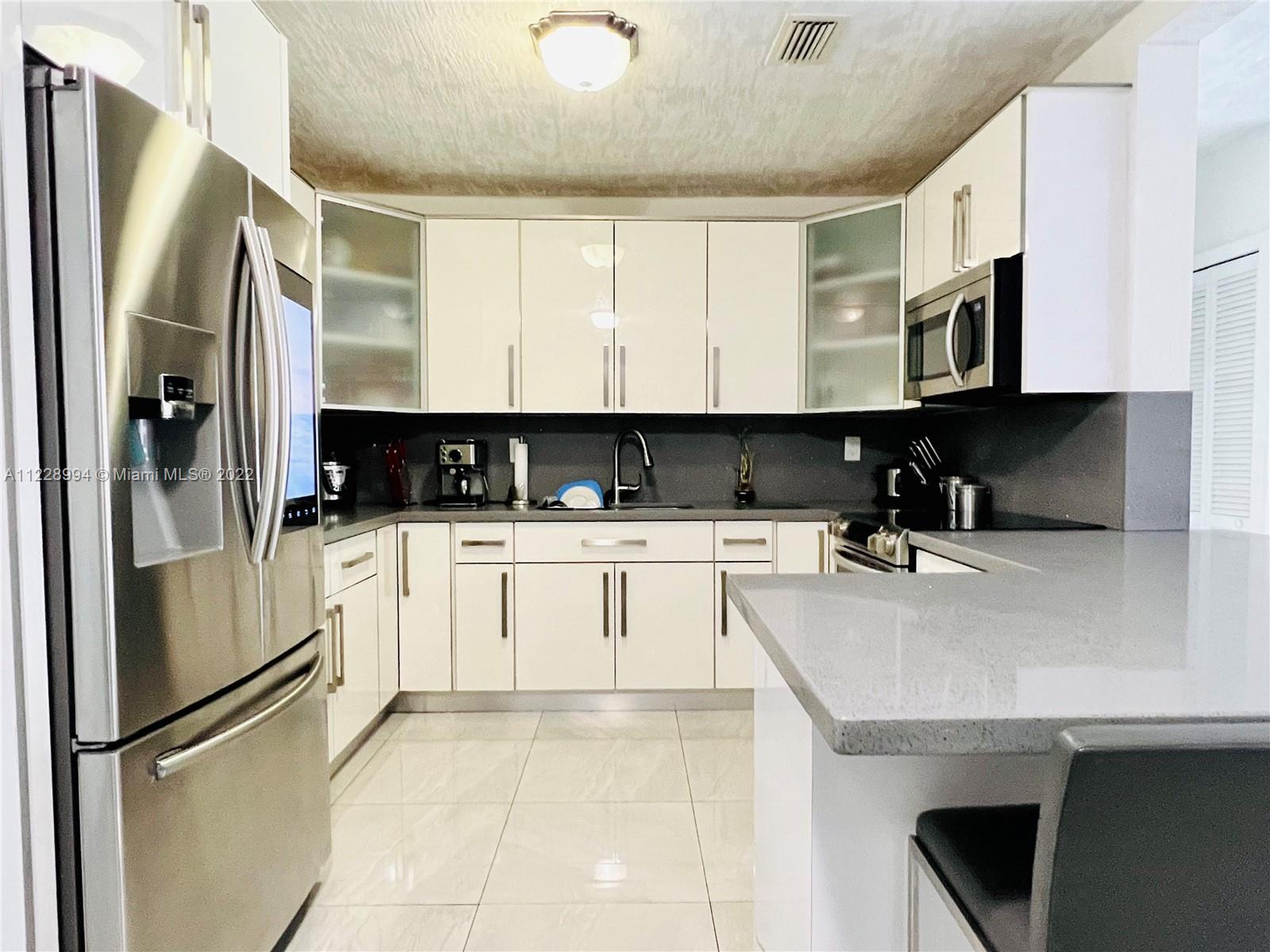 599 West 46th Place Hialeah, FL 33012 - Photo 7 of 25 a kitchen with stainless steel appliances granite countertop a refrigerator sink and stove