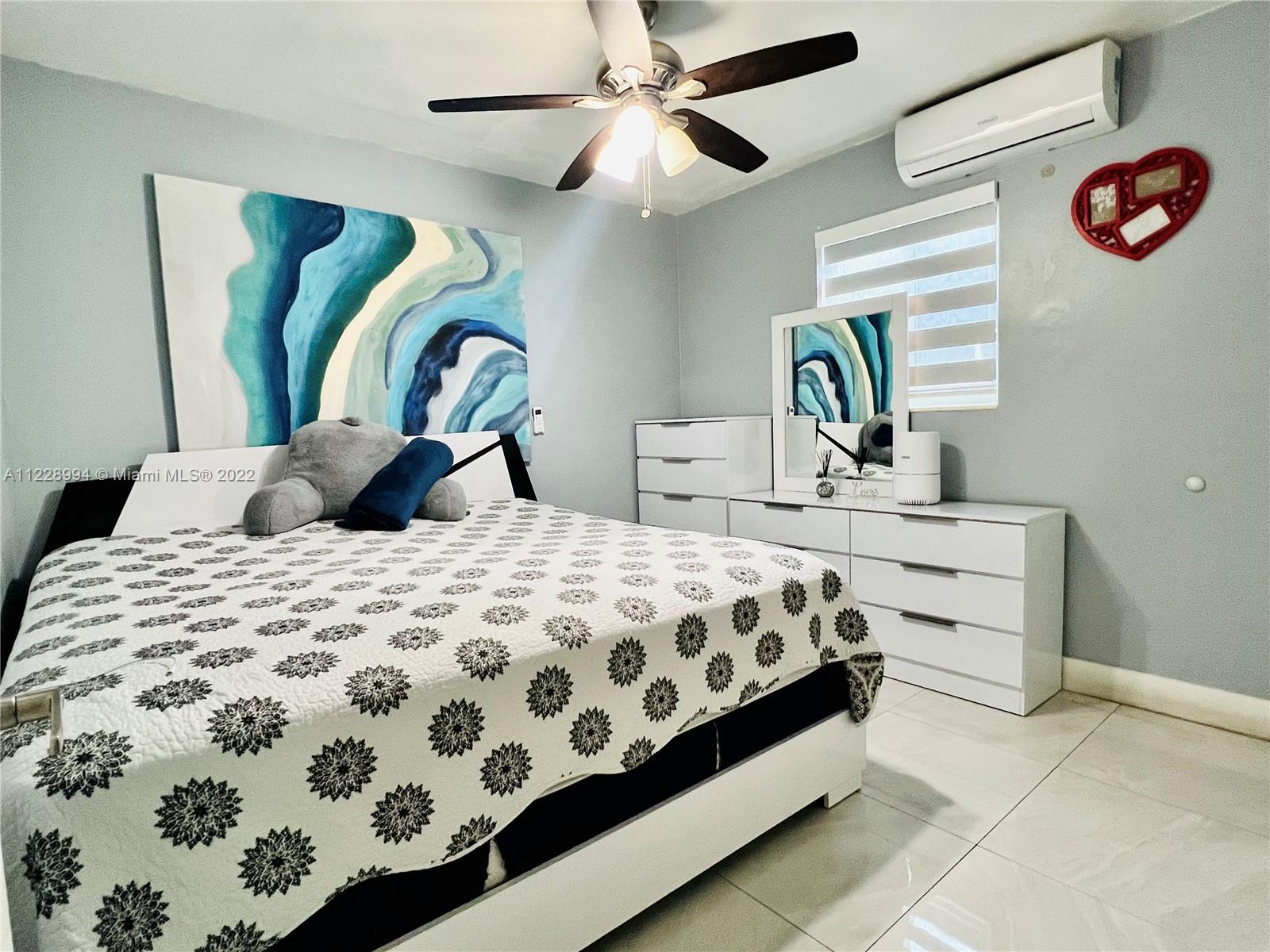 599 West 46th Place Hialeah, FL 33012 - Photo 8 of 25 a bedroom with a bed and a chandelier