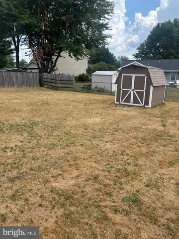 a view of a house with backyard and tree