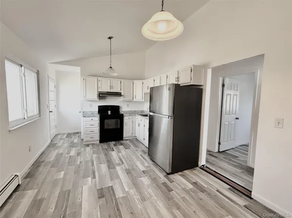 a kitchen with a refrigerator a sink and cabinets