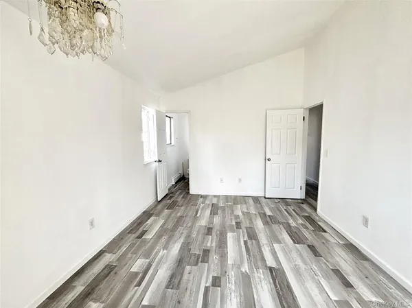 a view of a room with wooden floor and white walls