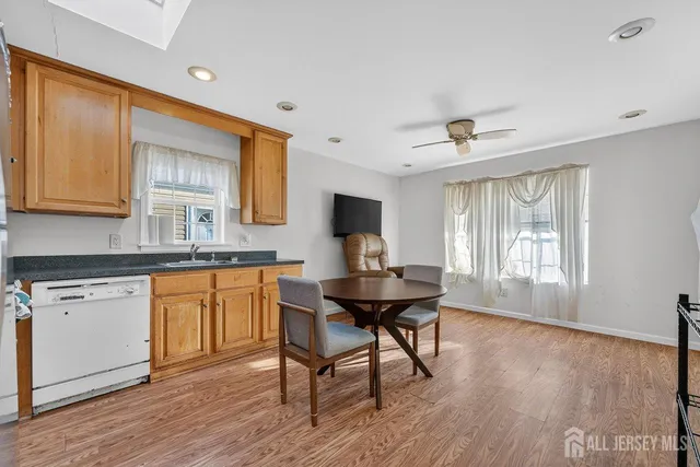 a kitchen with stainless steel appliances granite countertop a kitchen island hardwood floor sink stove dining table and chairs