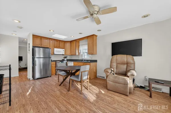 a living room with furniture and a refrigerator