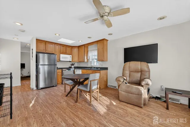 a living room with furniture and a refrigerator
