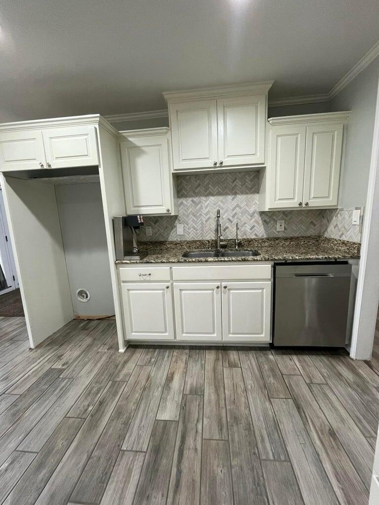 1415 Ebeling Drive Plainview, TX 79072 - Photo 13 of 46 a white kitchen with wooden floors a sink and white cabinets
