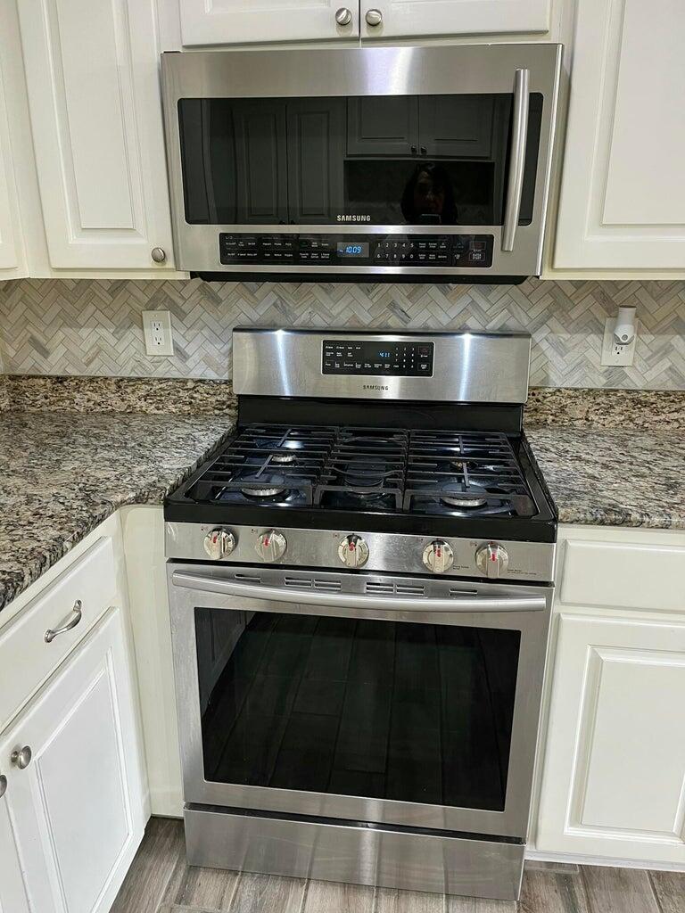 1415 Ebeling Drive Plainview, TX 79072 - Photo 14 of 46 a kitchen with granite countertop a stove and a microwave