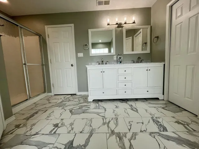 a bathroom with a sink mirror and cabinets