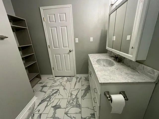 a bathroom with a granite countertop sink toilet and shower